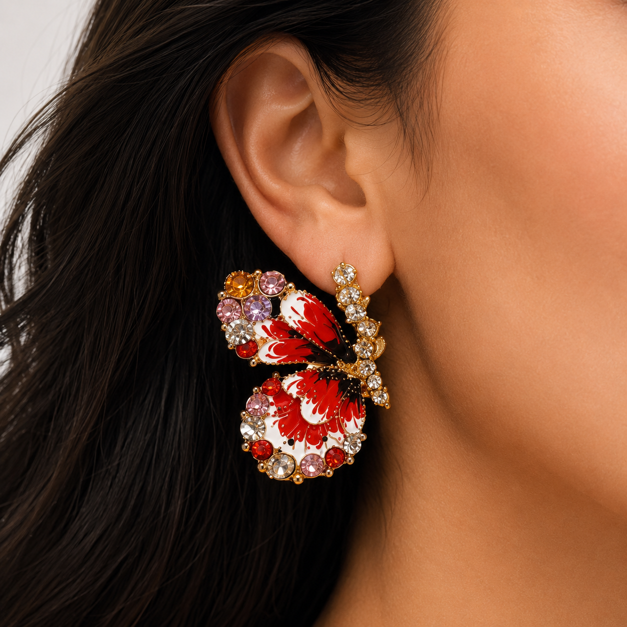 Close up of red butterfly earring worn by woman