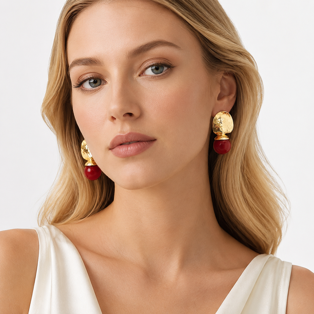 Woman wearing gold red drop earrings