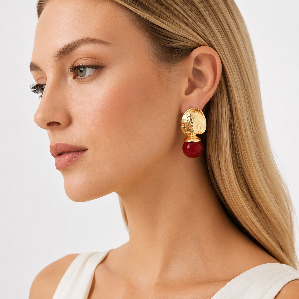 Side view of woman wearing gold red drop earrings