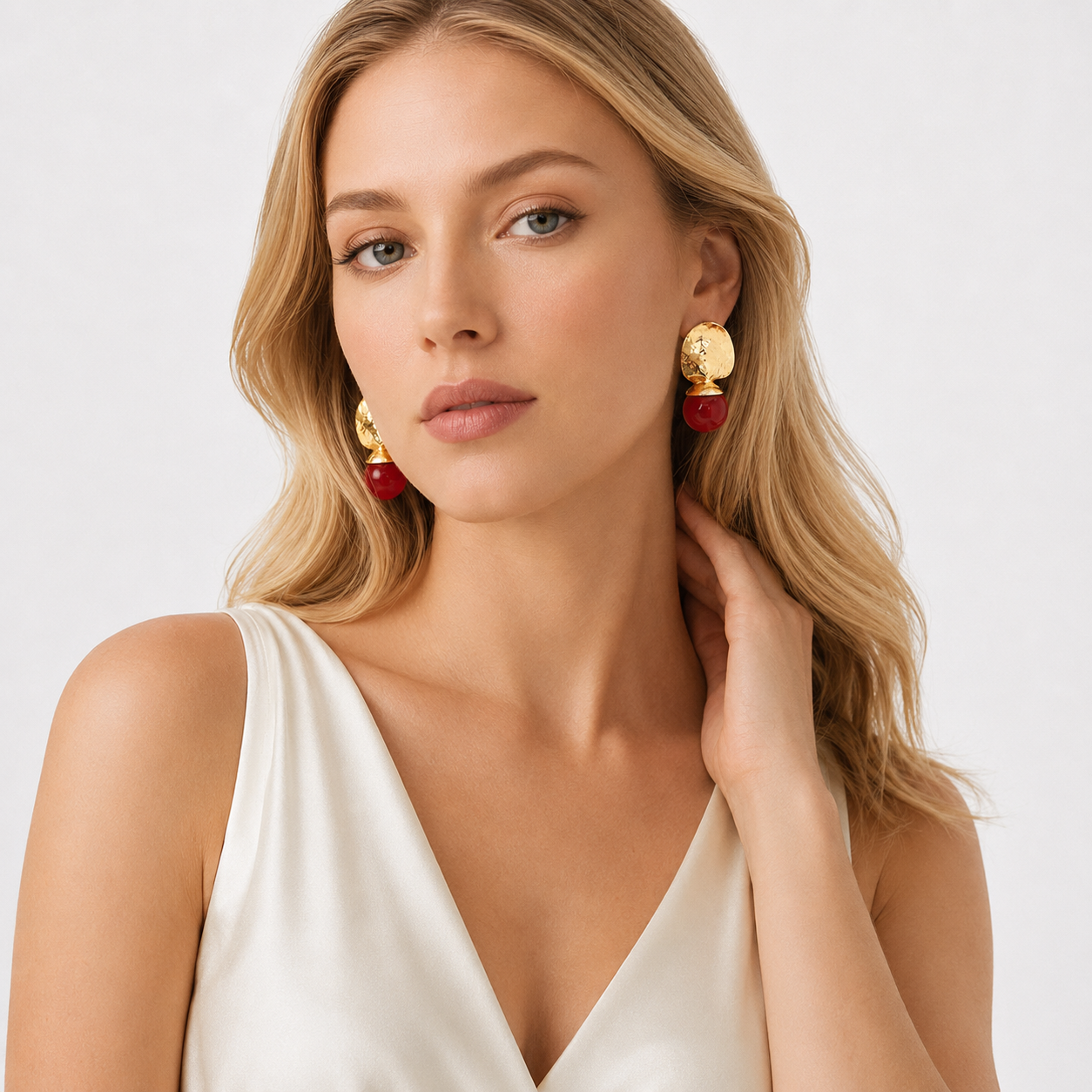 Model styling gold and red statement earrings