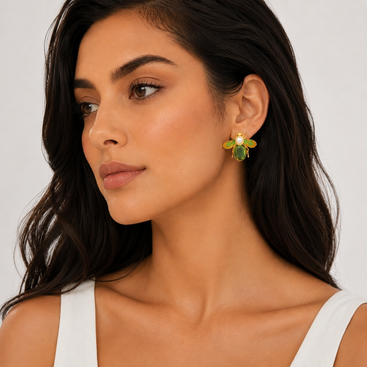 Side view of woman wearing green bee earrings